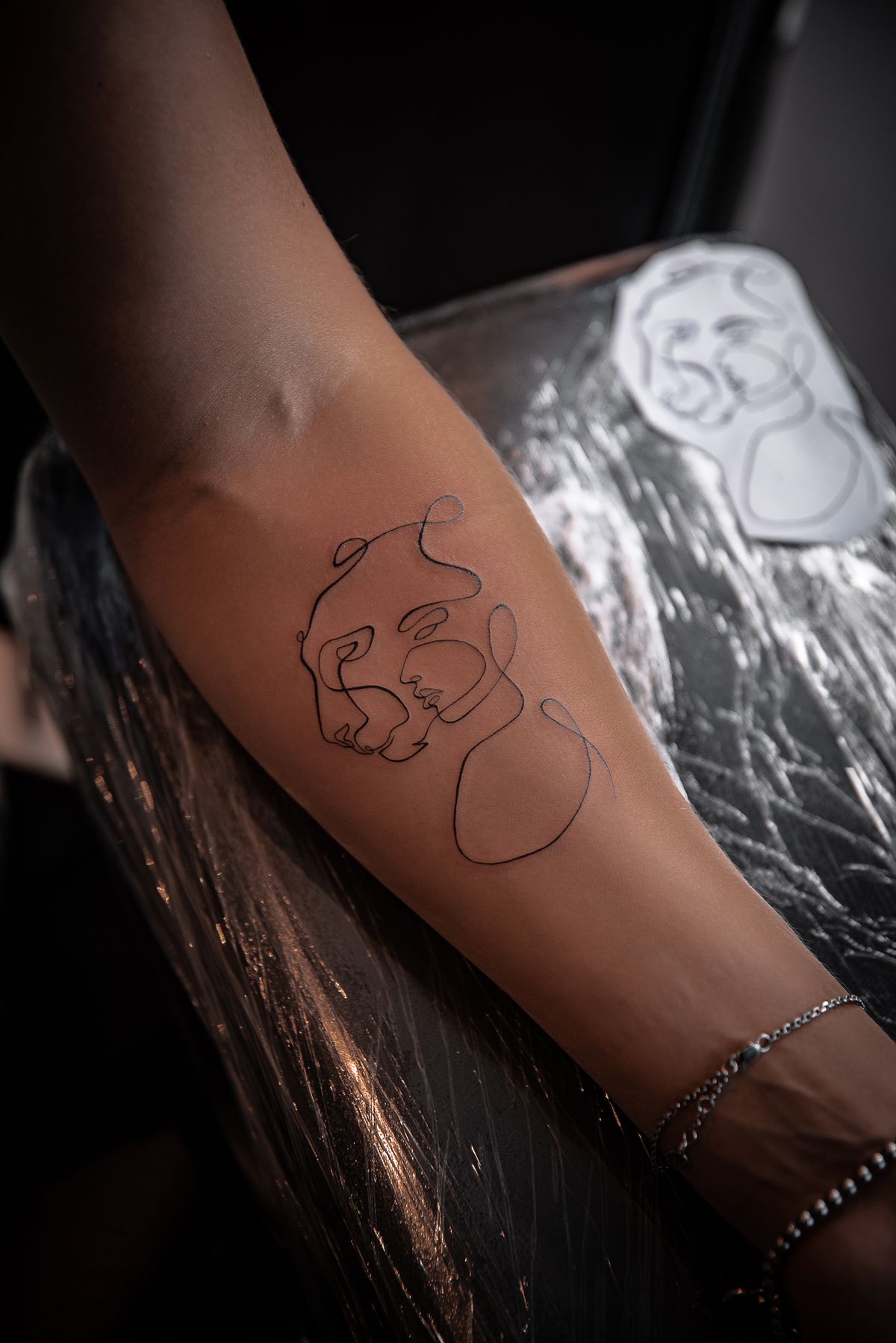 Minimalist fine line tattoo on a forearm