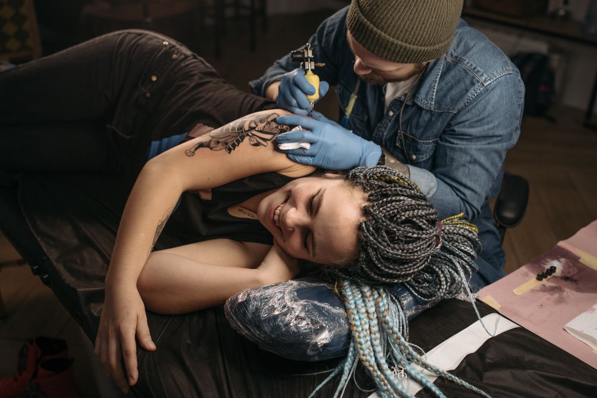 Woman getting her first tattoo in a tattoo parlor