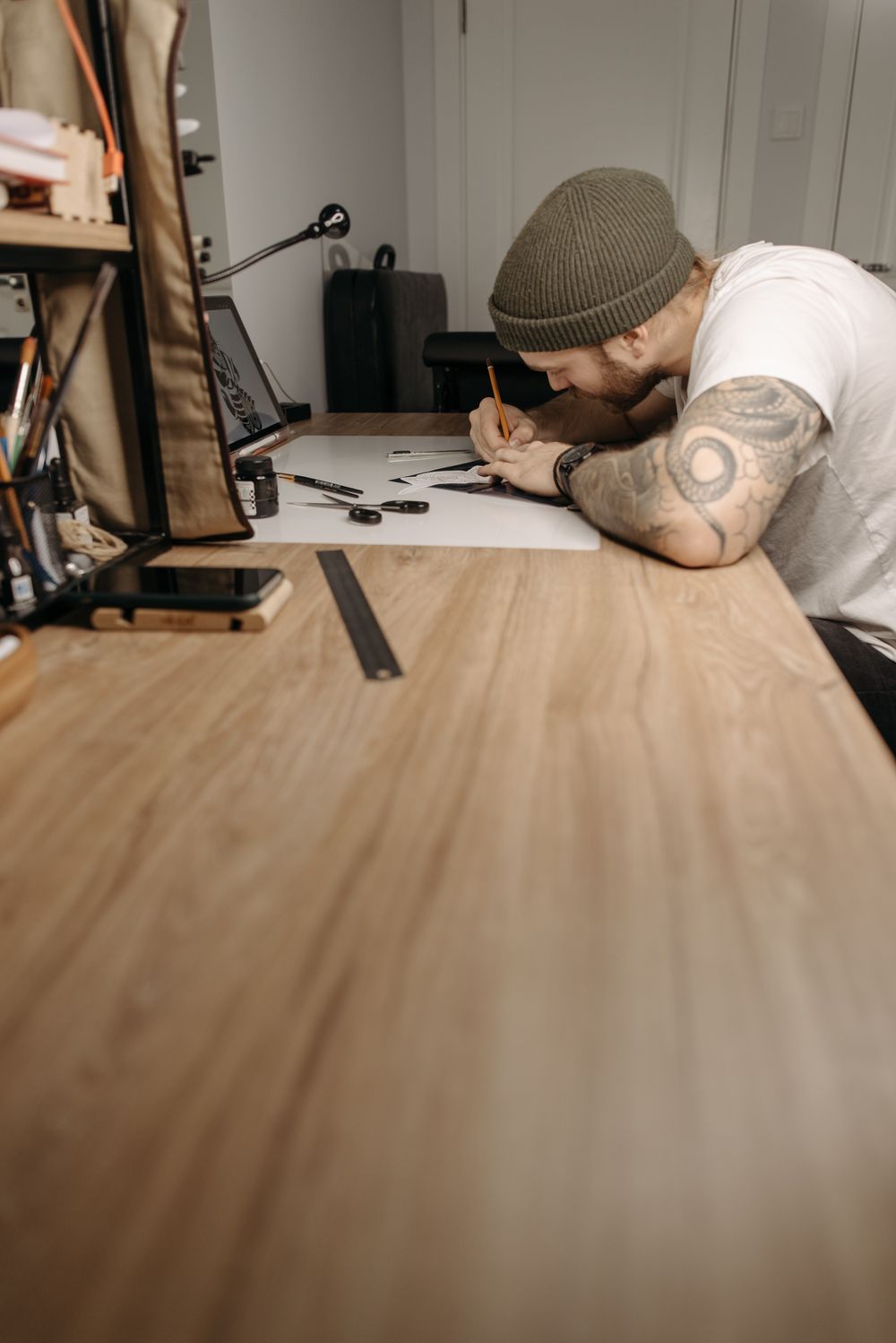 A tattoo artist hand-drawing a design in a studio