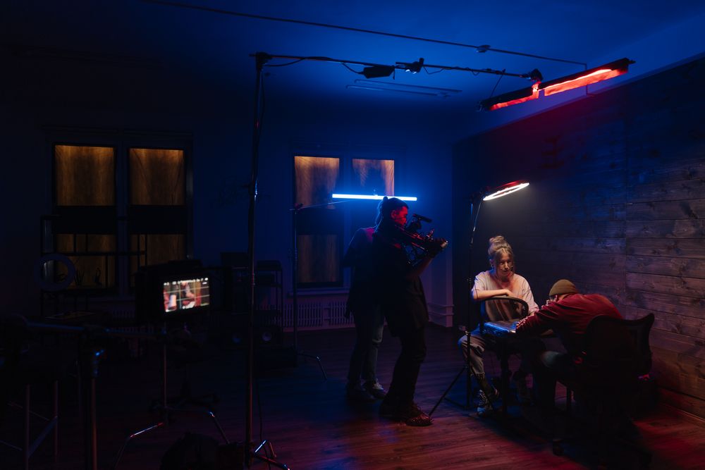 A film crew setting up lighting to shoot content in a studio