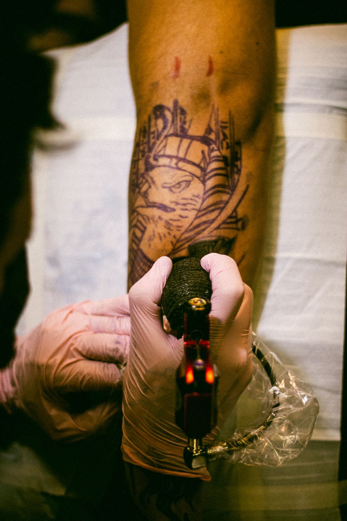 Tattoo artist inking a detailed design on a forearm