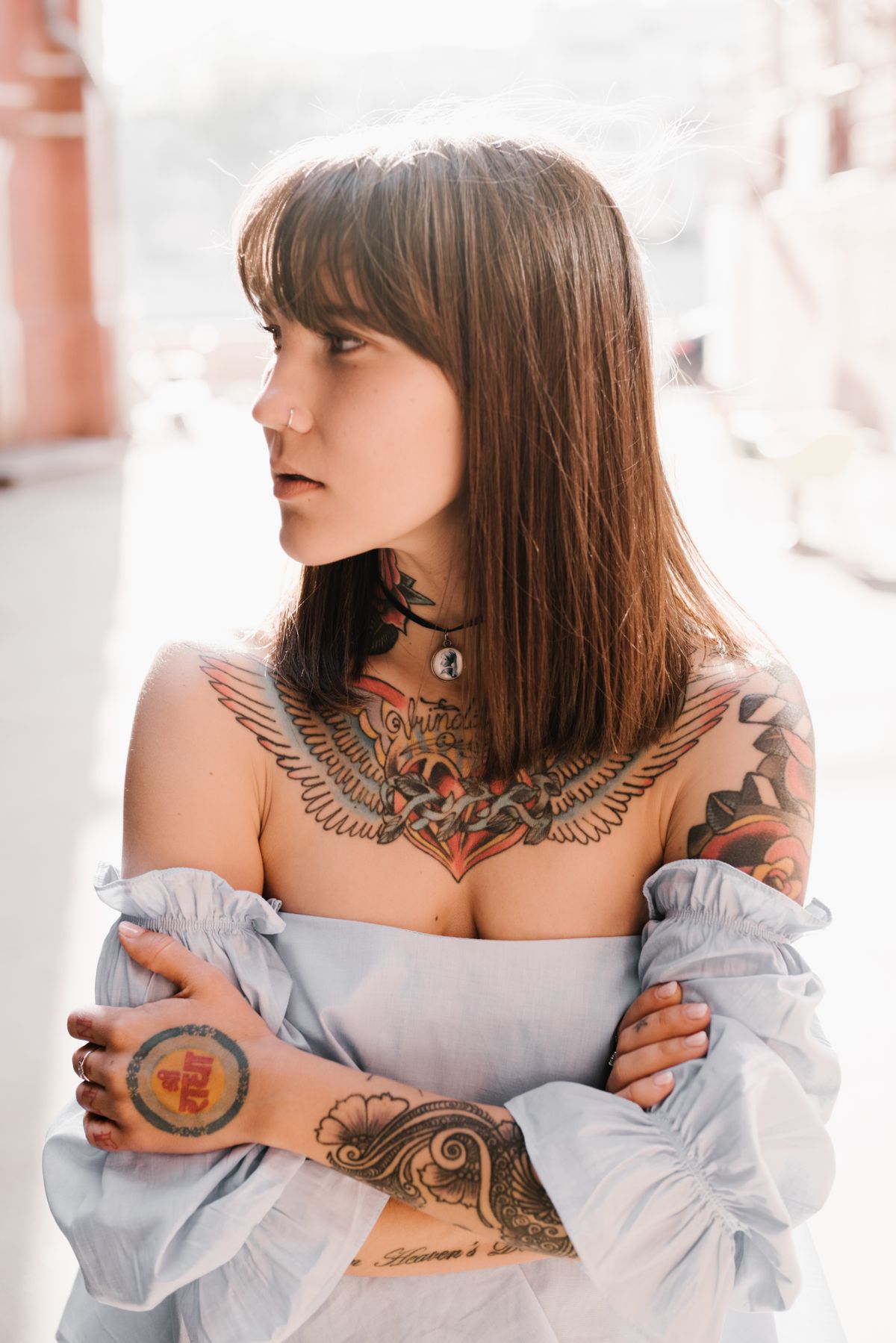 Stylish woman with tattoos in natural sunlight