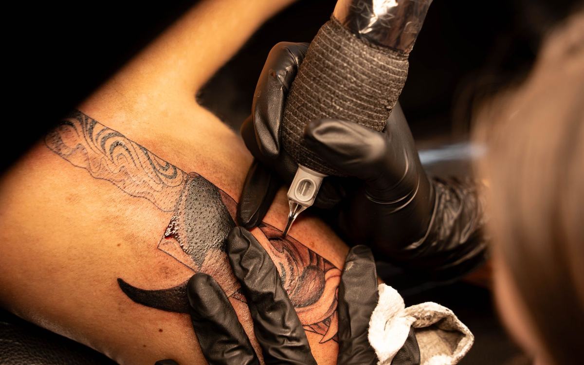 Close-up of a tattoo needle and ink during a tattoo session