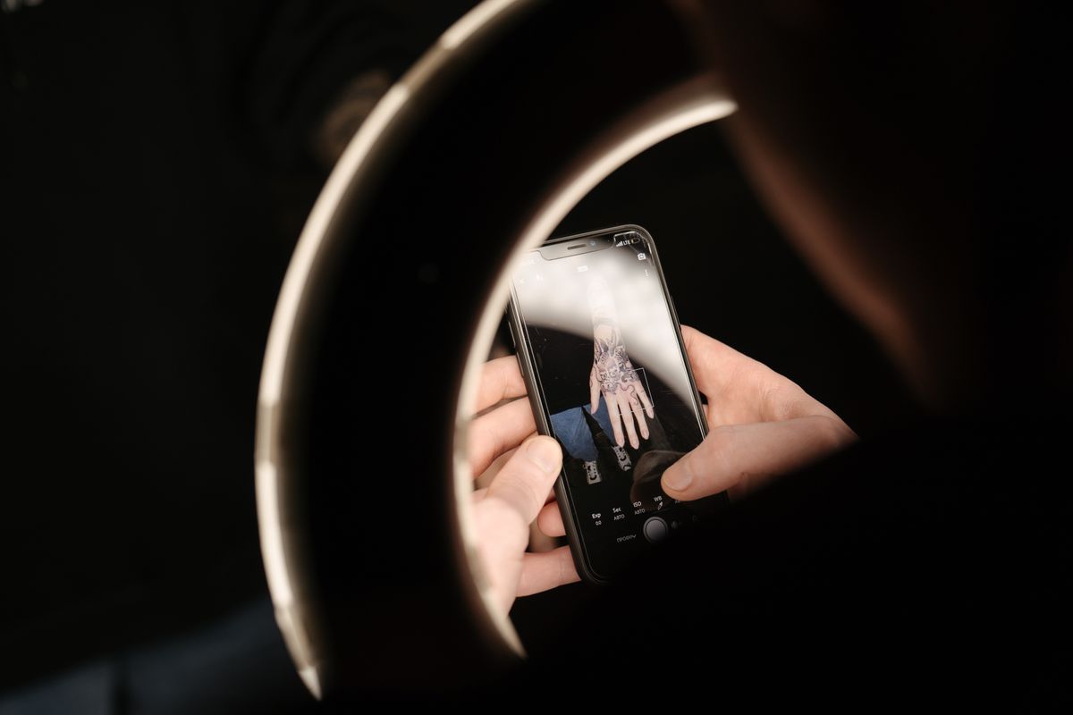 Close-up of a tattoo photographed on a smartphone with ring light